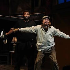 Actors performing a serious dramatic scene onstage