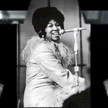 Aretha Franklin performing onstage with a microphone