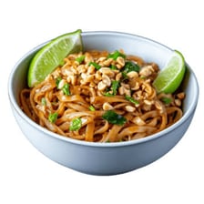 A plate of Pad Thai topped with crushed peanuts and lime.
