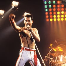 Queen performing with Freddie Mercury onstage.