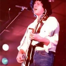 Folk singer Arlo Guthrie performing with a guitar