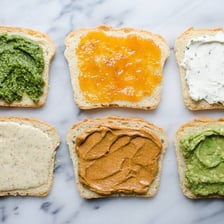 Mayonnaise spread on the bread of a sandwich.