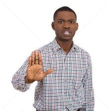 A person raising a hand to signal that someone should stop.