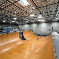 Tony Hawk performing a skateboarding trick on a ramp.