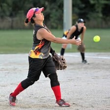 A softball pitcher lobbing the ball in a slo-pitch game.
