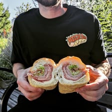 A long hoagie sandwich filled with meat, cheese, and vegetables.