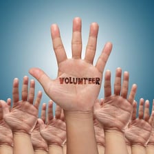A volunteer raising a hand to offer help