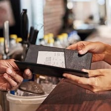 A person offering to pay a restaurant bill