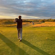 A golfer playing on a links-style golf course