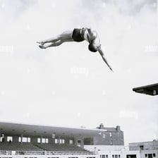 A diver twisting in midair after jumping from a diving platform.