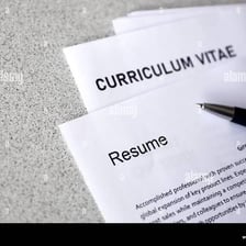 Printed job resumes arranged on a desk.