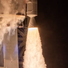 A rocket lifting off with visible engine thrust.