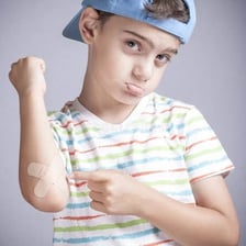 A person reacting to a painful bump while holding an injured arm
