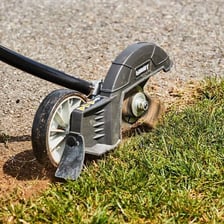A lawn edger cutting a neat border along grass