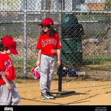 A preteen baseball player in a Little League uniform