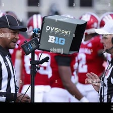 A sports referee reviewing a replay on a monitor