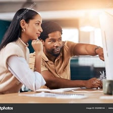 An assistant helping another person with work at a desk
