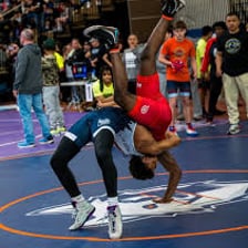 Two wrestlers competing on a wrestling mat