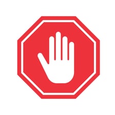 A person making a raised-hand gesture meaning stop.