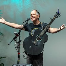 A singer performing a folk song with an acoustic guitar