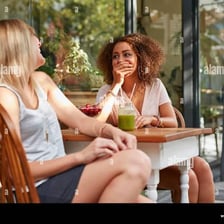 Friends engaged in casual conversation at a café.