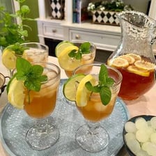 A glass of iced tea served with ice and a lemon slice.
