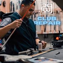 A technician fitting a new grip onto a golf club.
