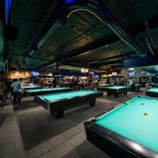 Several billiards tables arranged in a pool hall