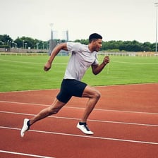 A runner accelerating on a track.