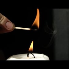 A match lighting a candle