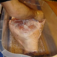 Salt being used to cure meat.
