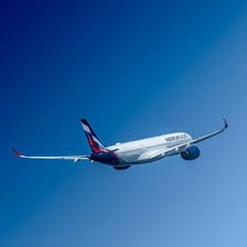 A passenger jet flying against a blue sky
