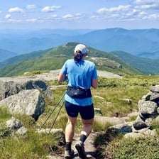 A person climbing upward on a mountain trail.