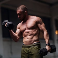 A person performing dumbbell biceps curls during a workout