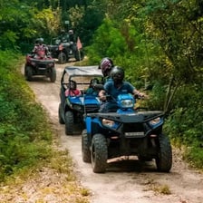 An all-terrain vehicle driving along a rugged trail.