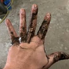 Hands visibly covered with dark grime and grease