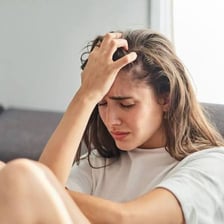 A person looking distressed while dwelling on a concern.