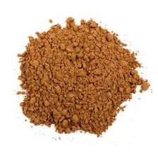 Brown carob pods beside carob powder