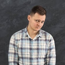 A portrait of a person with a shy, reserved expression