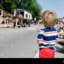 A child standing on tiptoes to see a parade