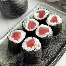 A sliced tuna sushi roll wrapped in dark nori.