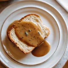 A piece of bread soaking up gravy.