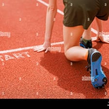 A runner stands with their toes at a marked starting line.