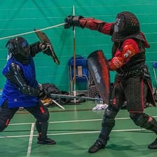 Two opponents facing each other in a formal fencing duel.