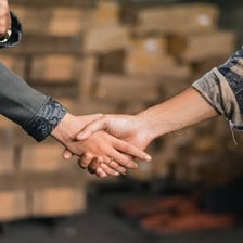 Two people shaking hands as one makes a promise
