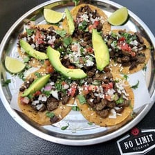 Grilled carne asada tacos served at a taqueria