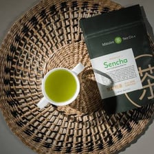 Green tea leaves and brewed tea representing nokcha and sencha