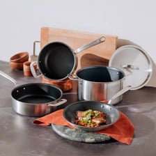 Several frying pans and other cookware arranged on a kitchen counter