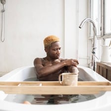 A person washing in a bathtub.