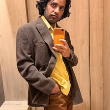 Person wearing clothing that fits well in front of a mirror.
